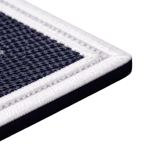 Side-profile macro shot of a trimmed cut-edge patch showing the raw 300D twill fabric cross-section and flat white border stitches.