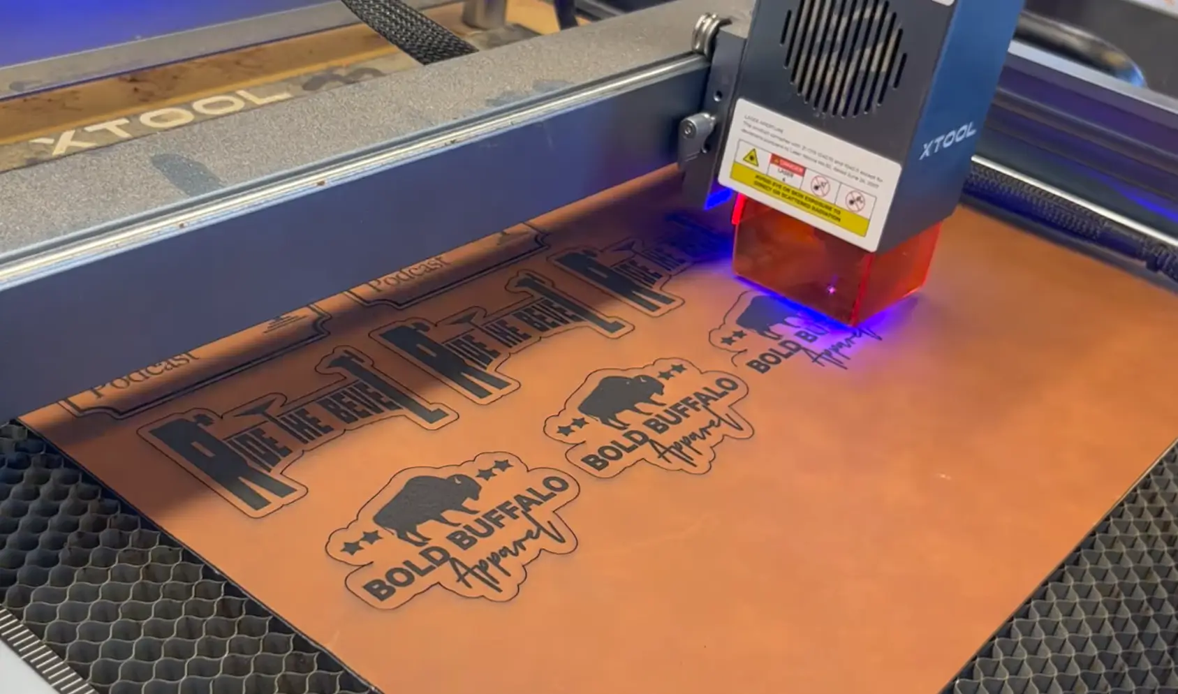 Laser engraving machine etching custom designs onto genuine leather sheet for leather patches