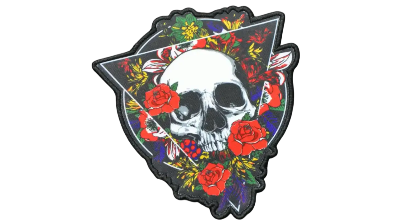 Dye-sublimated skull patch surrounded by red roses and floral accents with a black merrowed border, shown on black background.