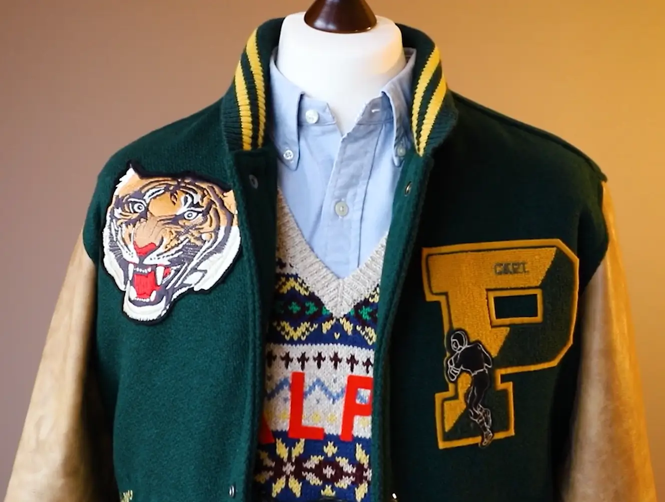 varsity jacket featuring chenille letter patch and embroidered tiger mascot patch on front panel